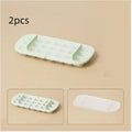 High capacity plastic ice cube tray with lever handle and integrated storage for ice shovel.