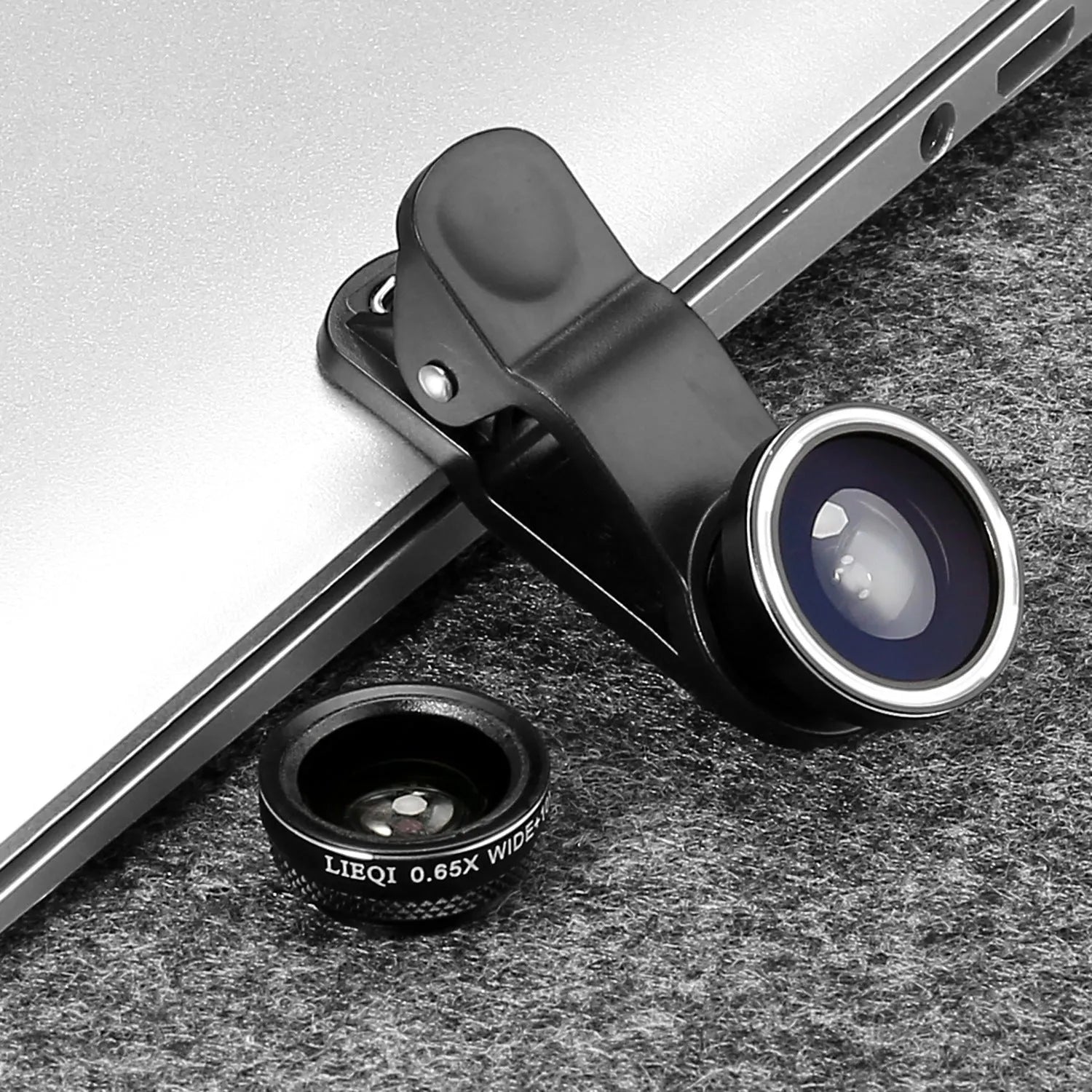 Mini camera lens clip for mobile phone in black attached to smartphone showing clip-on design