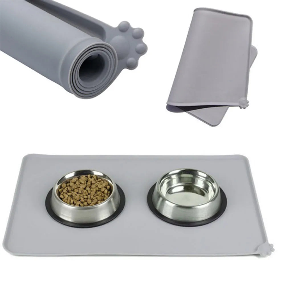 Grey waterproof silicone pet mat with raised edges and a non-slip base, measuring 47x29.5cm, placed under two pet bowls
