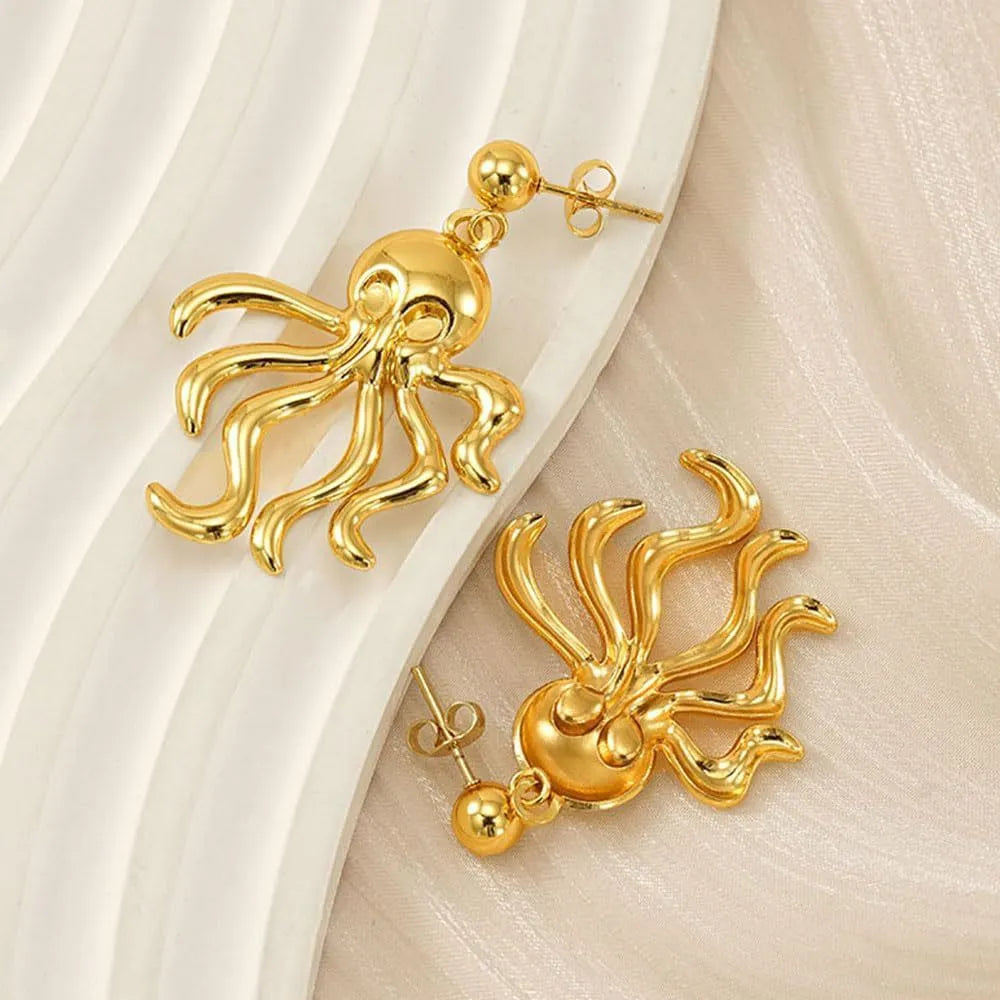 Gold stainless steel octopus drop earrings on a neutral background