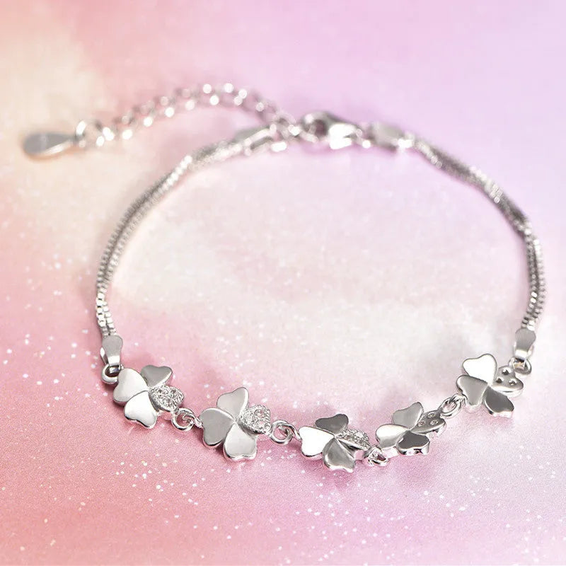 Silver four-leaf clover bracelet with adjustable chain on white background