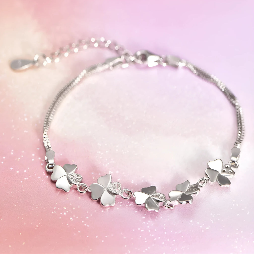 Silver four-leaf clover bracelet with adjustable chain on white background