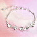 Silver four-leaf clover bracelet with adjustable chain on white background