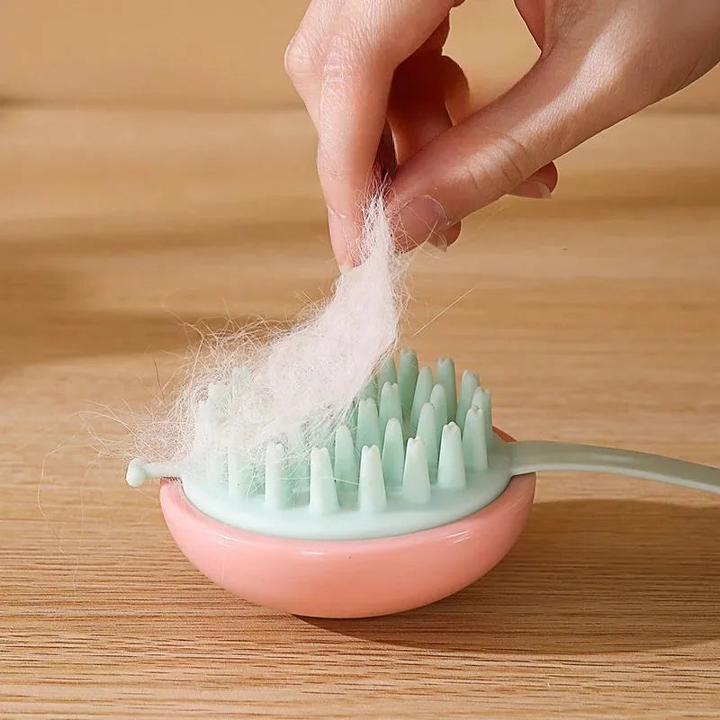 Blue silicone pet bathing and grooming brush with soft bristles and an ergonomic handle.