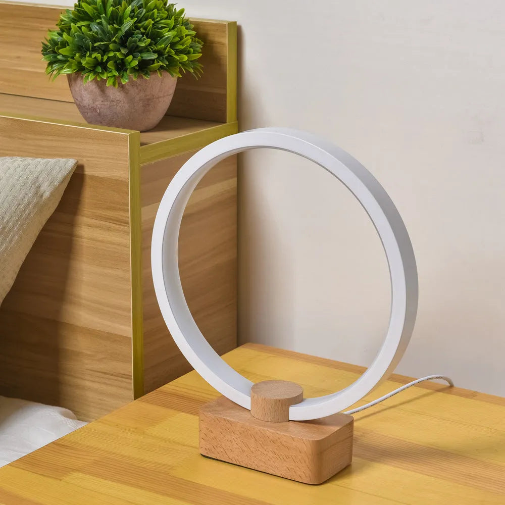 Round small solid wood and bamboo USB-powered LED night lamp on a table.