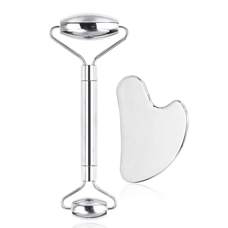 Stainless steel facial massage roller and heart-shaped gua sha scraping plate on a simple background.