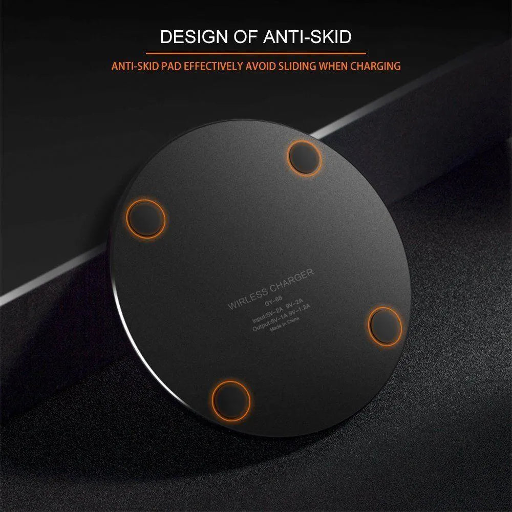 Black ultra-thin square wireless charging pad with USB cable on a desk.