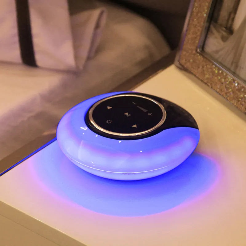 Folding Bluetooth desk lamp and speaker with touch controls showing blue atmospheric LED light.