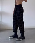 Men's plaid apron trousers showing the front bib design and adjustable straps.