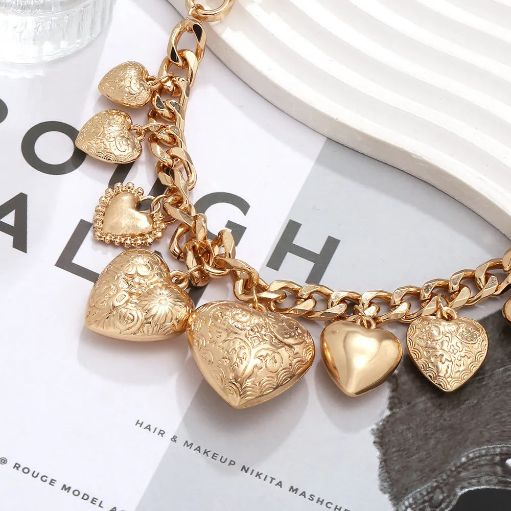 Gold carved heart pendant necklace on an adjustable metal chain.