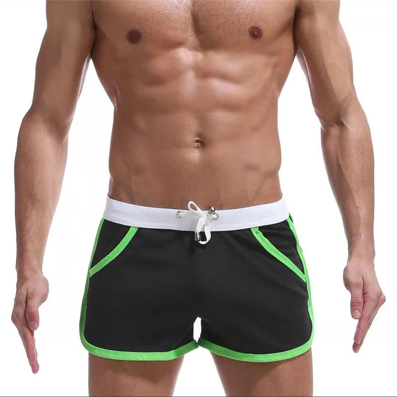 Summer men's quick-drying polyester beach sports shorts in green, with elastic waistband, front view