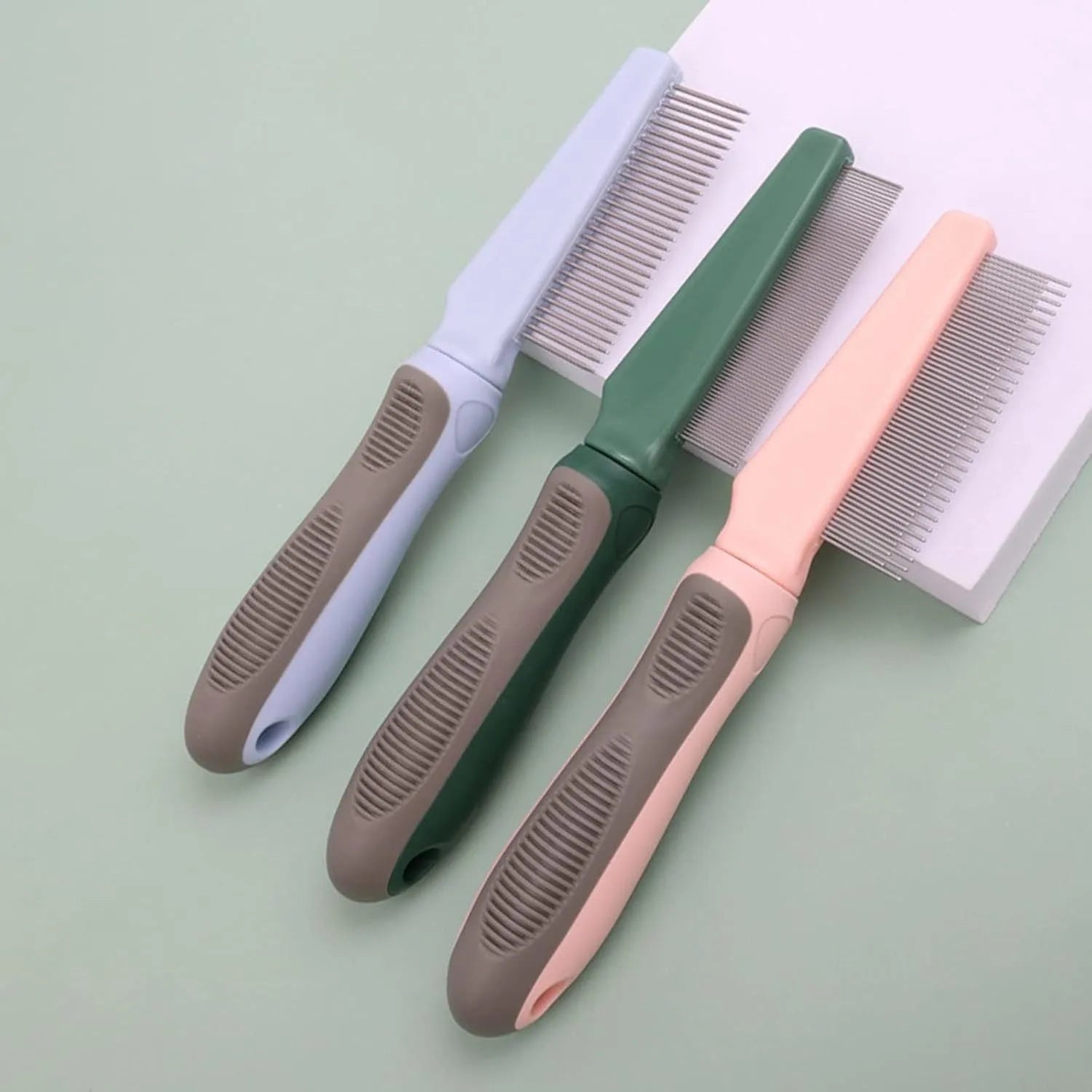 Pet grooming comb set showing three comb types with dense, high/low, and sparse needles on rubber handles