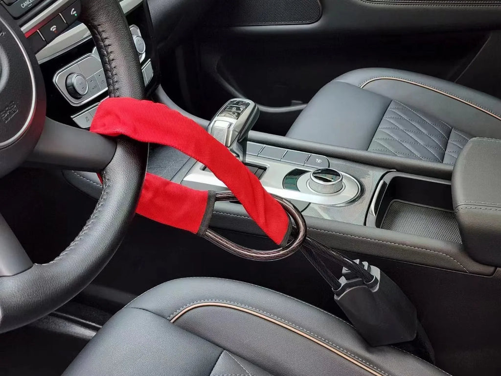 Red iron car steering wheel lock with copper core for General Motors vehicles on a steering wheel.