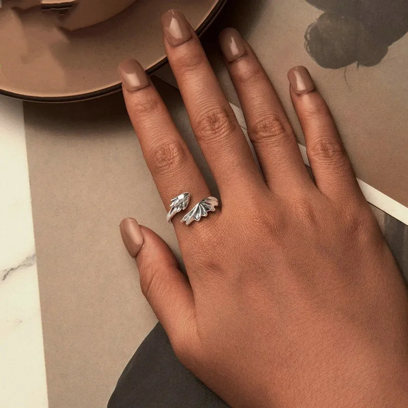 Unisex silver adjustable open ring with flying dragon wing motif on neutral background