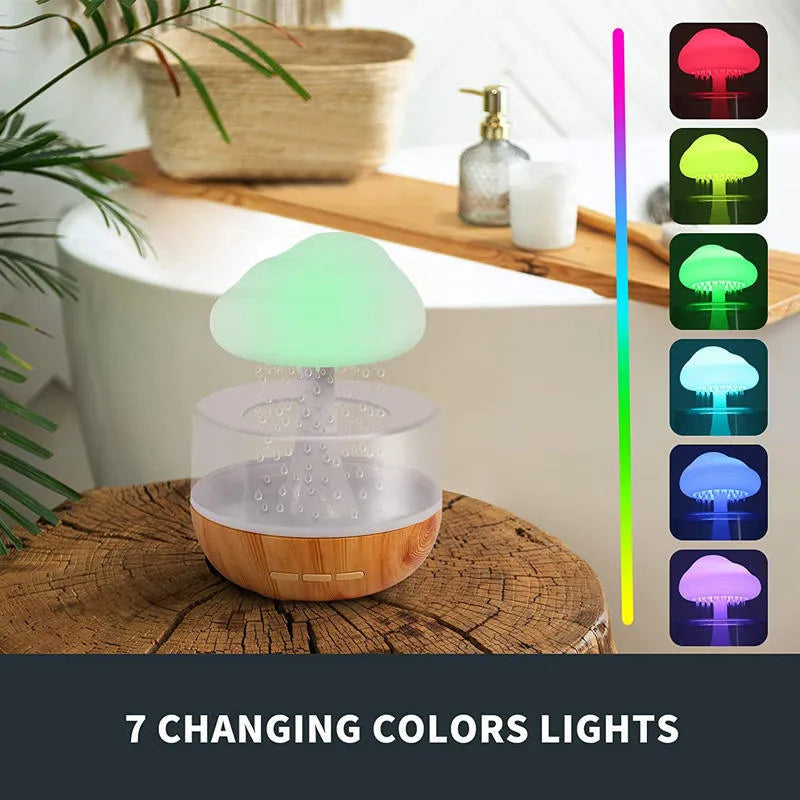 White rain cloud design desk humidifier and aromatherapy diffuser with mushroom-shaped night light on a wooden table.