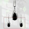 Black and red teardrop-shaped glass pendant necklace and matching earrings set made from alloy.