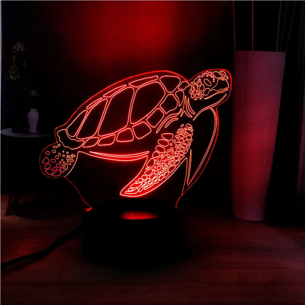 3D acrylic turtle shaped LED night light showing multi-coloured illumination on a shelf.