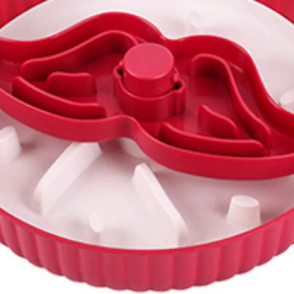 Rotating plastic pet feeding game board with blue silicone licking mat and a separate white bowl on a wooden table.