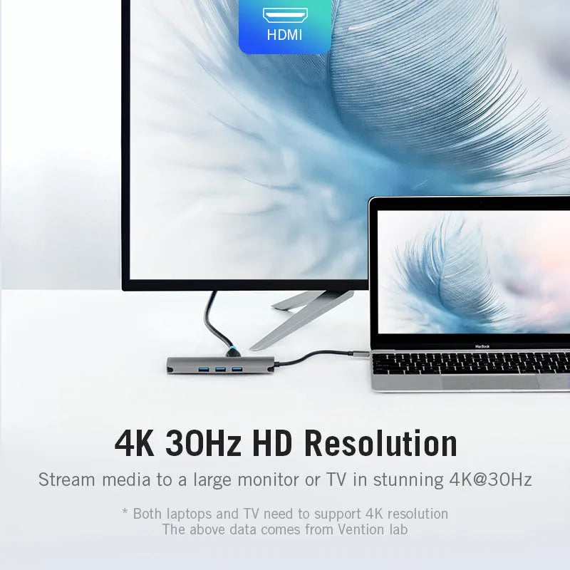 Deep grey USB-C hub with HDMI, USB, Ethernet, and memory card ports, shown next to a laptop.