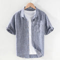 Men's light grey linen short sleeve shirt with a square collar, laid flat.