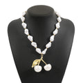 Gold tone irregular cherry and pearl necklace on a model, showing adjustable length up to 60cm.