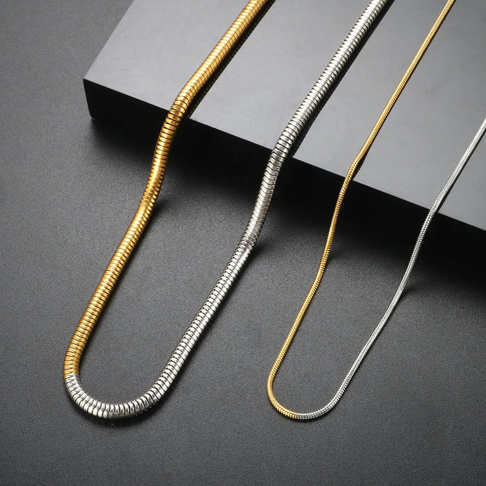 Gold tone stainless steel snake bone chain necklace with geometric line details, shown on a plain background.