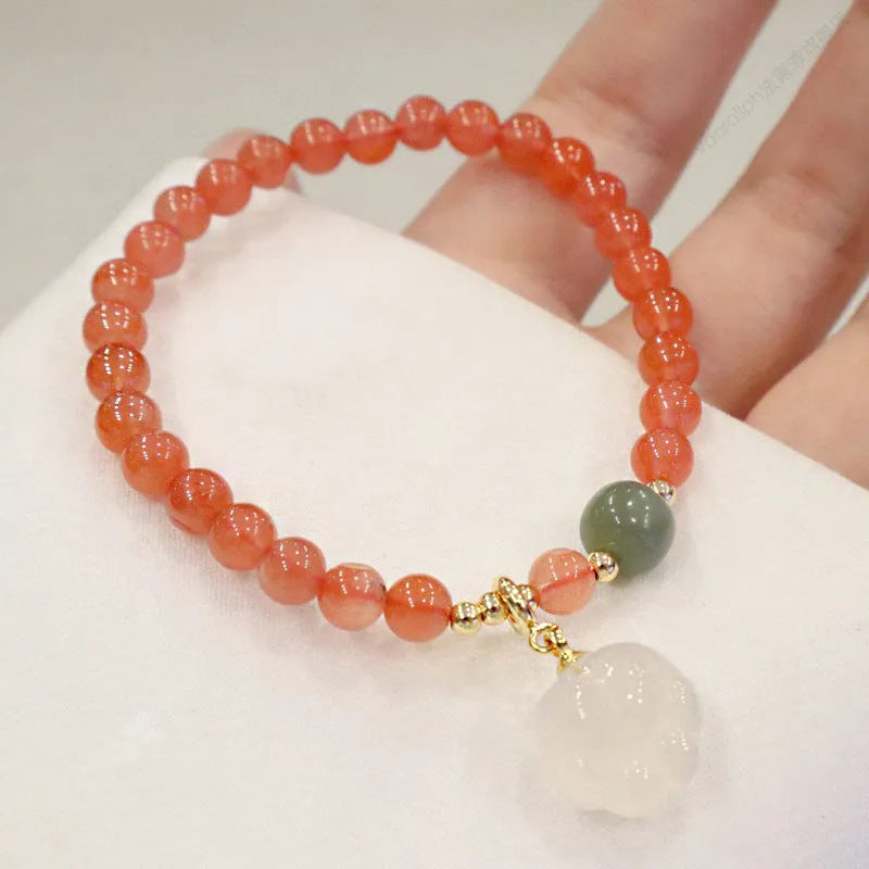 Polished agate bracelet with cat's paw charm and jade beads on adjustable cord.