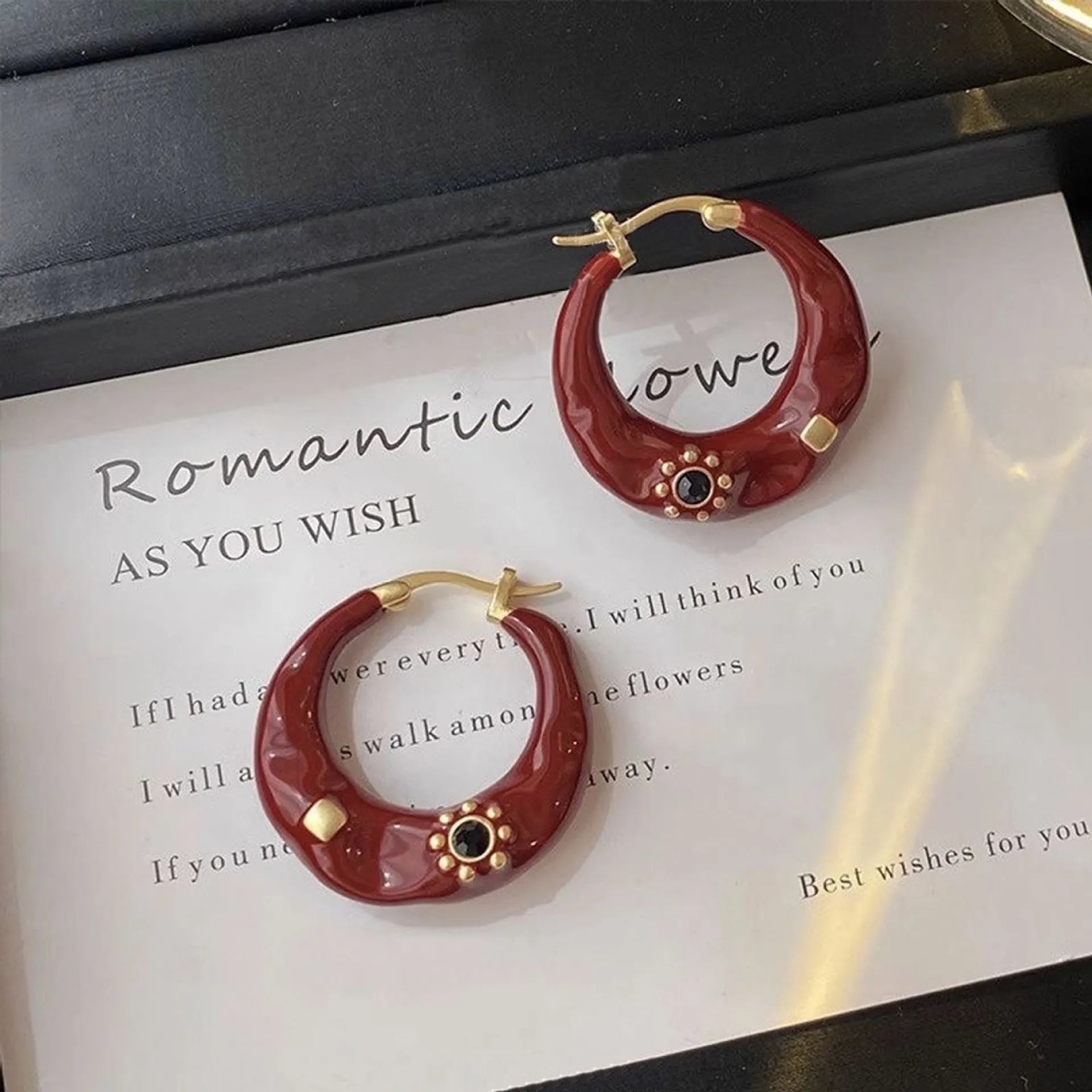A pair of retro-style alloy ear studs with inlaid rhinestones, shown in black and red colour options.