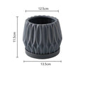 Grey small ceramic tabletop plant flowerpot on a desktop with a small green plant