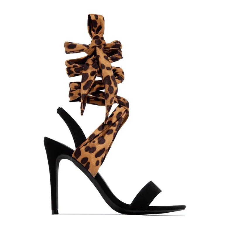 Light brown leopard print women's high heels with criss-cross ankle straps and a slim 8cm stiletto heel on a rubber sole.
