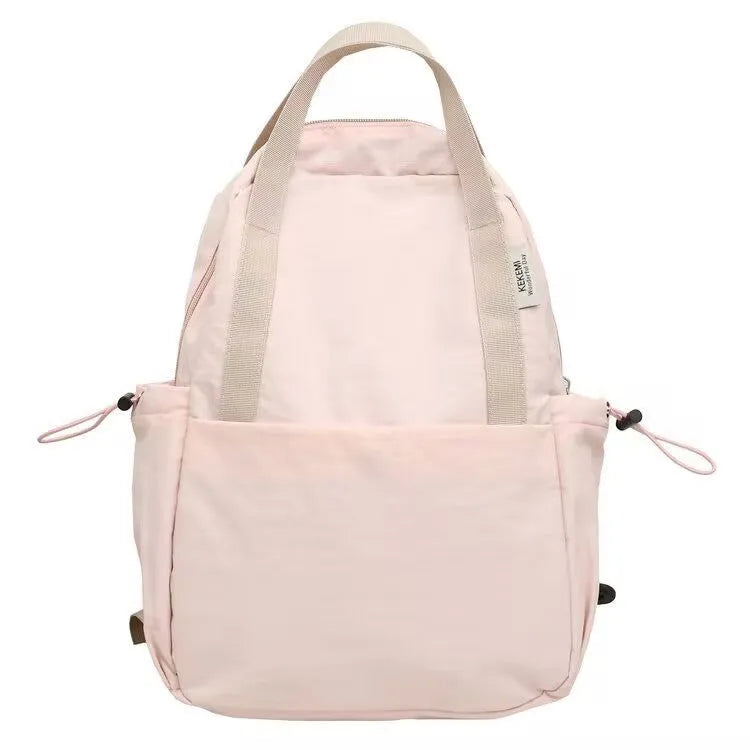 Simple solid colour nylon backpack in black on a neutral background, showing curved shoulder straps and top lock.