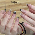 Assortment of sweet girl style false nails in various colours and designs, laid out on a table.