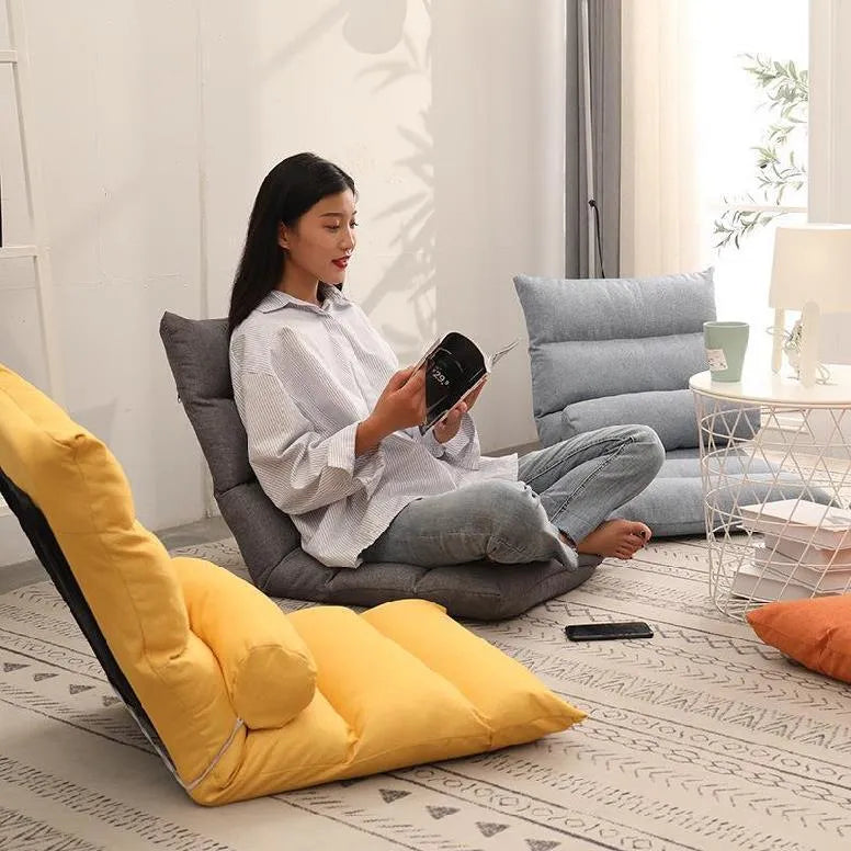 Beige lazy sofa floor chair with adjustable backrest on living room floor showing six-angle mechanism