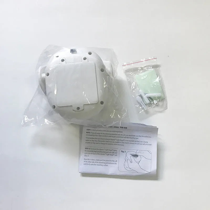 White Atomic Angel induction lamp with compact ABS housing on charging base.