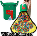 Green felt cube storage bag with pull rope, laid flat as a play mat next to toys.