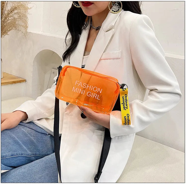A transparent square jelly cross-body bag in a choice of colours, shown with an adjustable strap and a mobile phone inside.