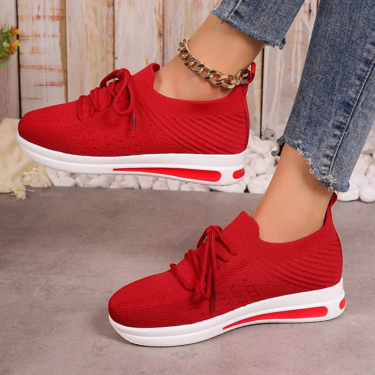 Women's red low-top lace-up sneakers with round toe and injection-moulded sole.