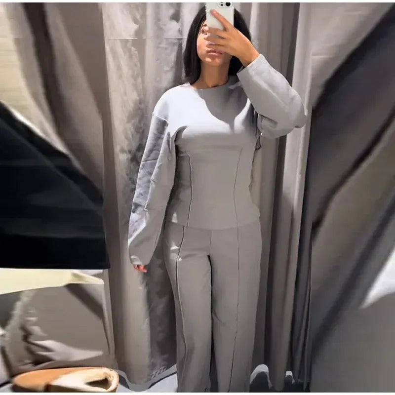Women's black polyester fleece two-piece suit with long sleeve top and wide-leg trousers on a hanger.