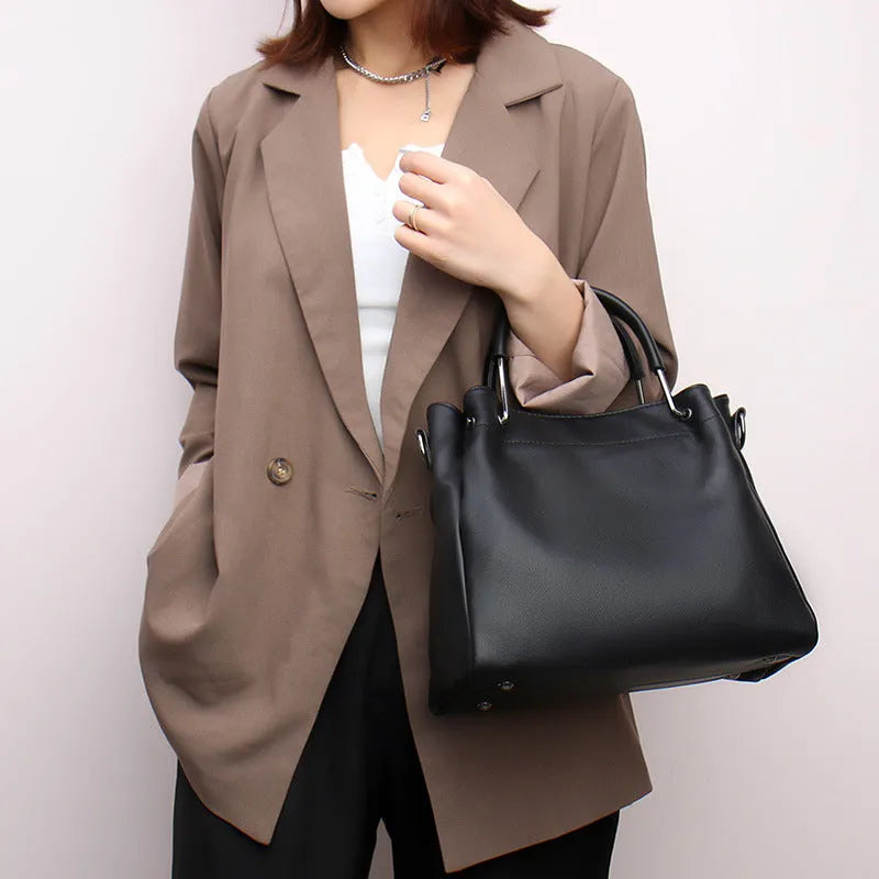 Leisure soft leather bucket bag in black with slit pocket and visible sewing thread detail for commuting