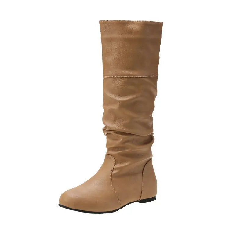 Women's flat black slip-on boots with a round toe and high cylinder shaft on a neutral background.