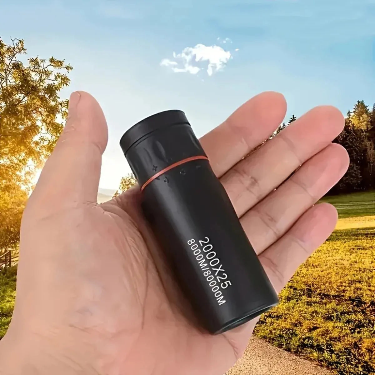 Black monocular telescope with mobile phone holder attached, showing compact single-tube design