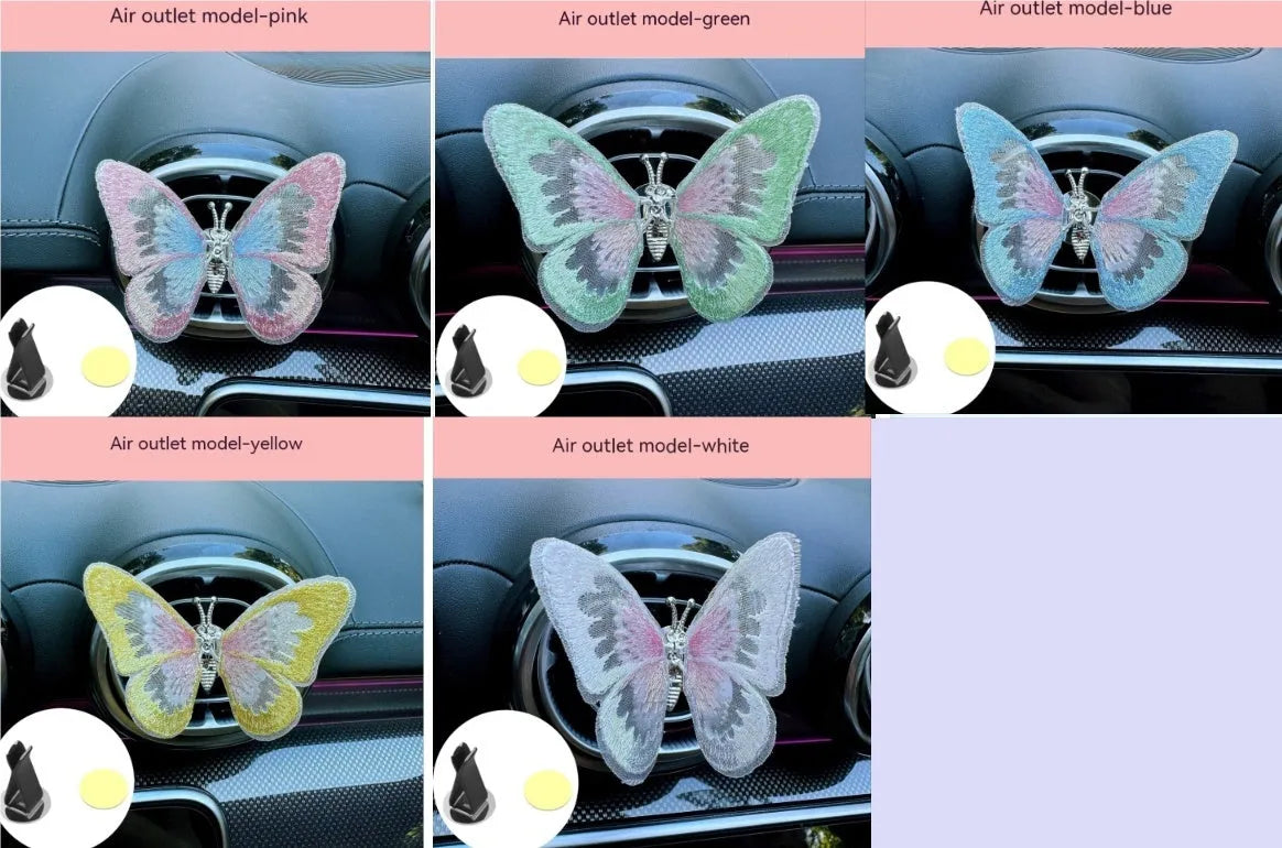 Soft fabric embroidered butterfly car air vent decoration in multiple colour options on a centre console.