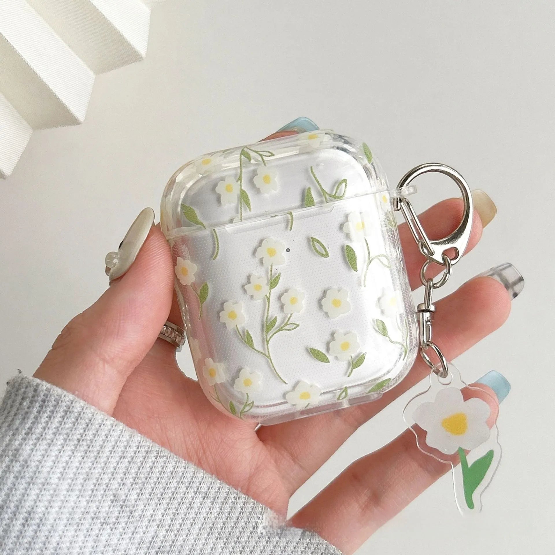 Clear TPU AirPods protective case cover with white floral design on transparent background