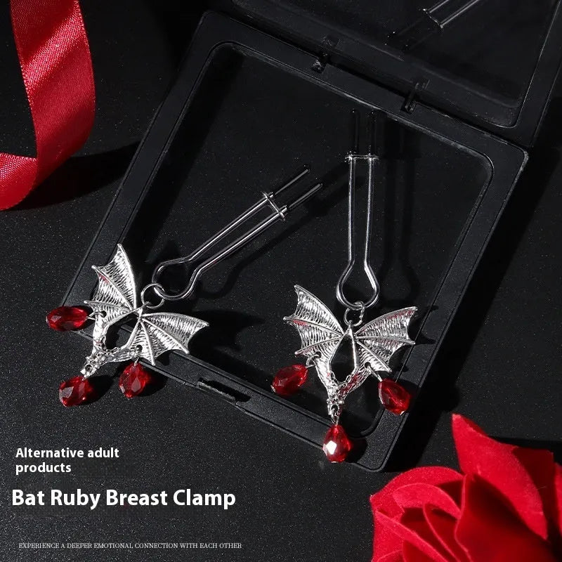 Silver alloy bat-themed nipple clamp with adjustable pressure and a red ruby decorative clip.