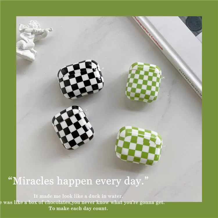 Black and green checkerboard pattern TPU protective case sleeves for Apple AirPods, one with a smiley face lanyard attached.