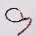 Hand-woven obsidian carrying strap bracelet showing textured surface and adjustable length