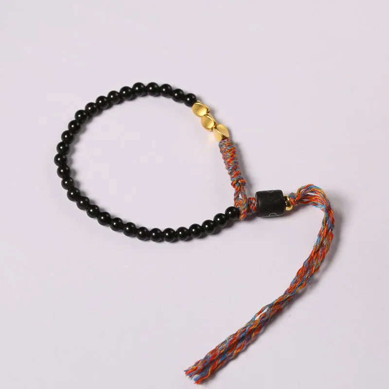 Hand-woven obsidian carrying strap bracelet showing textured surface and adjustable length