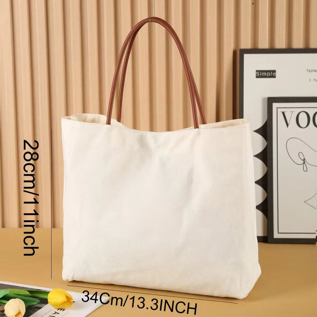Beige white canvas tote bag with detachable crossbody strap, side bottle pockets, and a front zipped compartment.