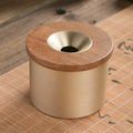 Brass ashtray with wooden lid in retro style showing middle hole design