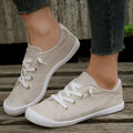 Women's creamy white casual low-top sneakers with fabric upper and rubber sole on a neutral background.